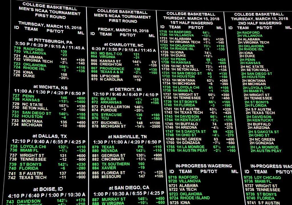 Betting lines for college basketball games are displayed at a retail sportsbook.